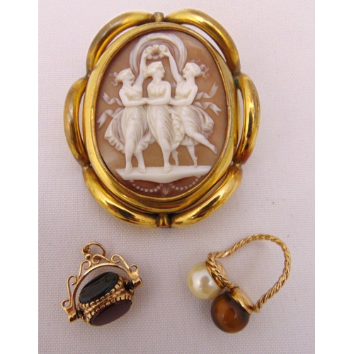 380 - A Victorian cameo brooch, a pearl and tigers eye ring and a coloured stone swivel