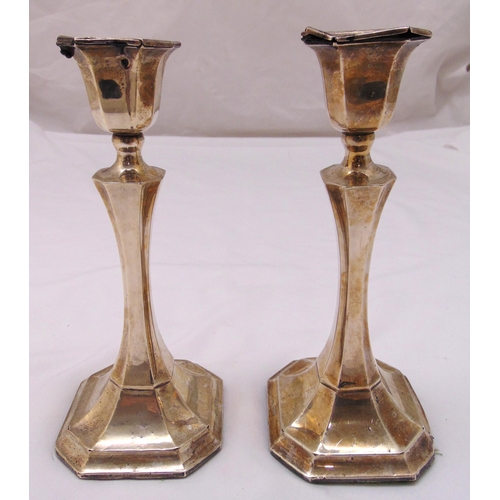 404 - A pair of hallmarked silver table candlesticks of faceted cylindrical stems on raised octagonal base... 