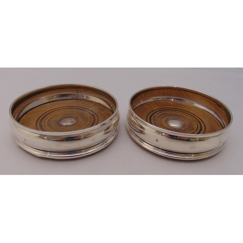 464 - A pair of hallmarked silver bottle coasters with turned wooden bases, 12.5cm (d)