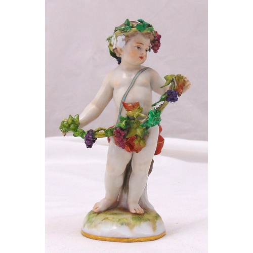 174 - A Meissen figurine of a putti with a garland of leaves and grapes on raised naturalistic base, marks... 