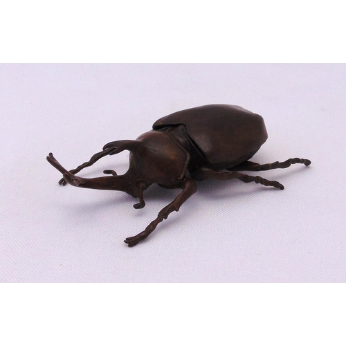 229 - A Japanese Okimono bronze figurine of a rhinoceros horn beetle with hinged wings, marks to the base,... 