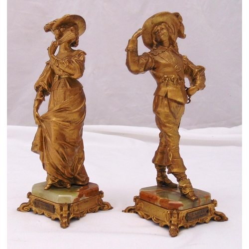 237 - A pair of gilded spelter figurines in 18th century attire on raised octagonal onyx and gilded metal ... 