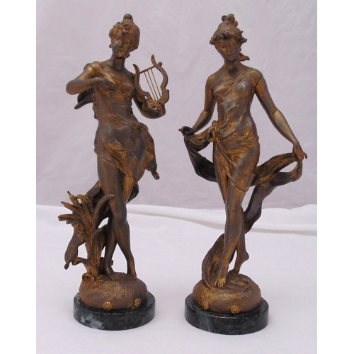 238 - A pair of spelter Art Nouveau style figurines of ladies in classical attire on raised circular bases... 