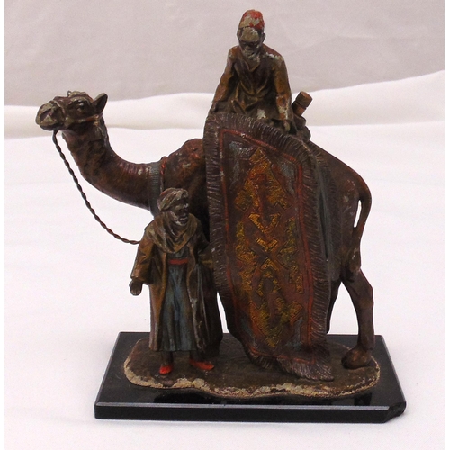 241 - A cold painted cigar lighter in the form of a carpet seller on a camel with accompanying figurine on... 