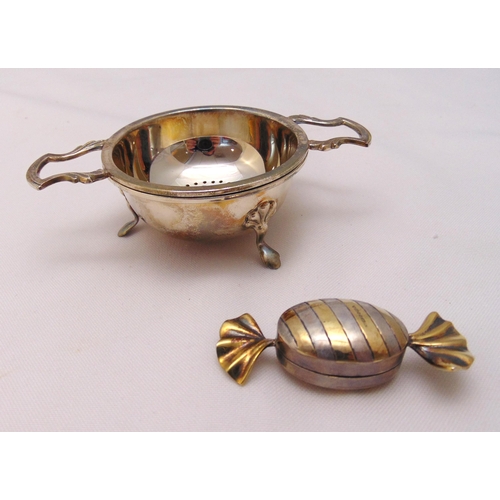 390 - A hallmarked silver tea strainer and stand and a pillbox in the form of a sweet, approx total weight... 