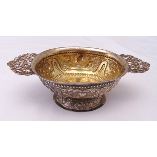 396 - A 19th century Dutch white metal shaped oval brandy bowl chased to the sides with masks and leaves, ... 