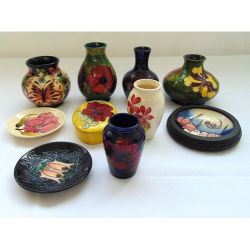 100 - A quantity of Moorcroft to include vases, dishes and an oval covered box, marks to thebases, tallest... 