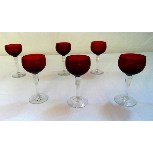 140 - A set of six cranberry coloured and etched hock glasses on raised circular bases