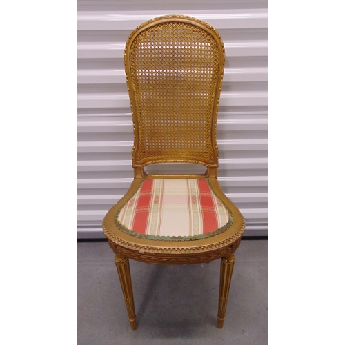 20 - A gilded wooden boudoir chair with rattan back and upholstered seat on four fluted tapering cylindri... 