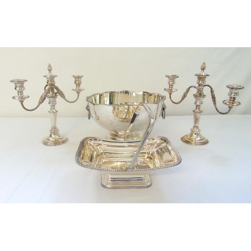 416 - A quantity of silver plate to include a punch bowl, a pair of candelabra and a bread basket with swi... 