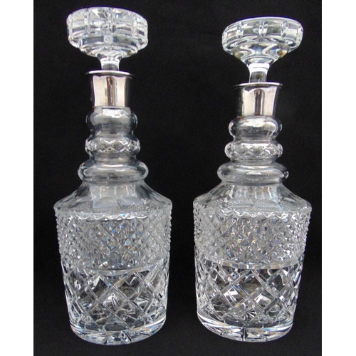 121 - A pair of cut glass decanters with drop stoppers and hallmarked silver collars