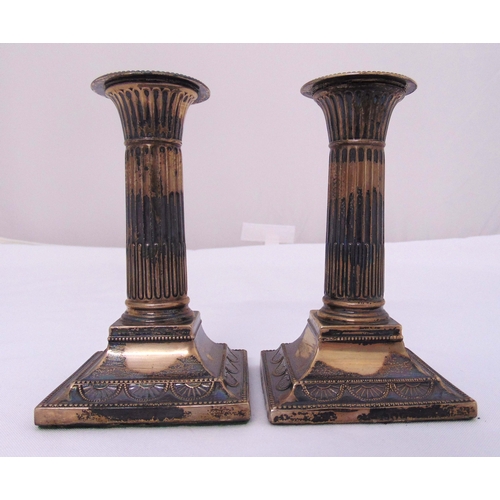 354 - A pair of late Victorian hallmarked silver table candlesticks with fluted stems on raised square bas... 