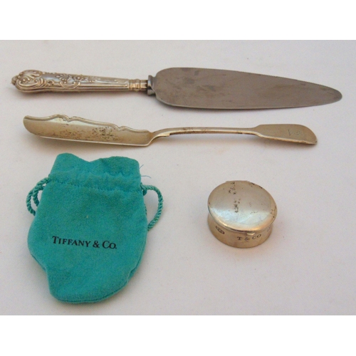 392 - Tiffany and Co white metal pillbox stamped 925, a hallmarked silver butter knife and a cake slice wi... 