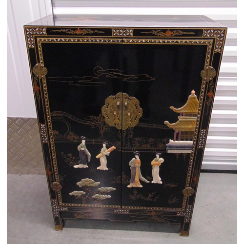 15 - An oriental rectangular black lacquered cabinet, hinged doors, brass mounts with applied stoneware f... 