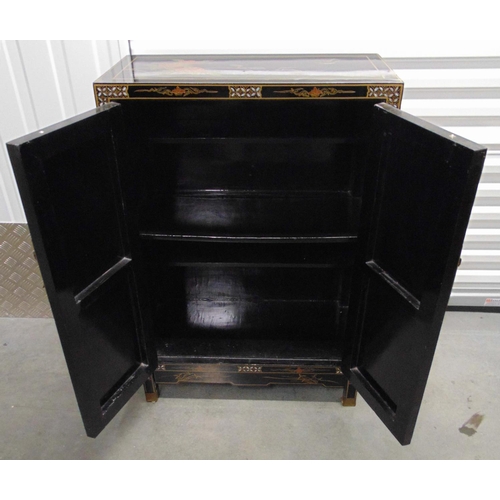 15 - An oriental rectangular black lacquered cabinet, hinged doors, brass mounts with applied stoneware f... 