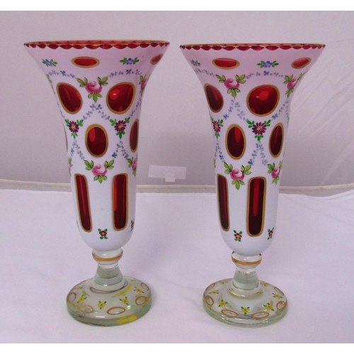 172 - A pair of Bohemian Opaline and ruby glass vases with floral swags and leaves on raised circular base... 