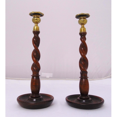 227 - A pair of brass and wooden barley twist table candlesticks on raised circular bases, 34cm (h)