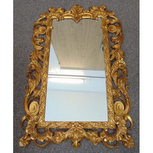 36 - A Rococo style gilded wooden rectangular wall mirror, pierced and carved with leaves and flowers, 97... 