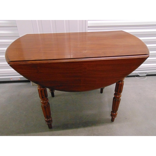 4 - An early 20th century circular mahogany drop flap table on four turned supports, 66.5 x 98cm