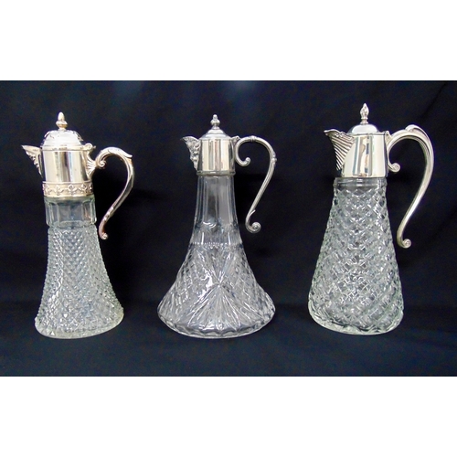 136 - Three cut glass and silver plated claret jugs all with scroll handles and hinged domed covers, talle... 