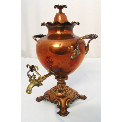 143 - A copper and brass Samovar of customary form with two scroll handles, domed pull off cover with flor... 