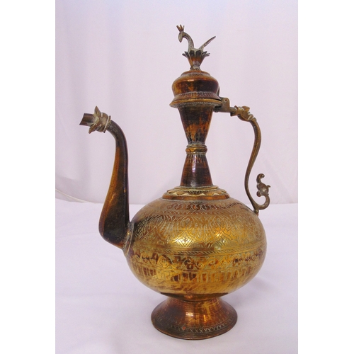 146 - A Middle Eastern brass water jug of compressed cylindrical form with scroll handle and spout, the do... 