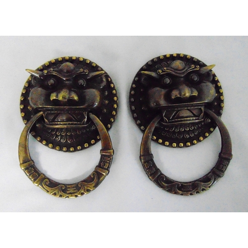 156 - A pair of oriental bronze door knockers, the lion masks with ring handles, 19 x 13cm