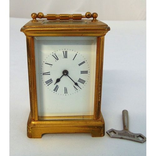 241 - A brass carriage clock of customary form with white enamel dial and Roman numerals, to include key, ... 
