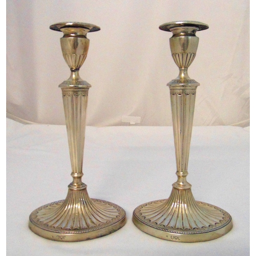 299 - A pair of Victorian hallmarked silver table candlesticks in late 18th century style, the fluted tape... 