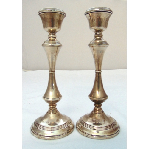 303 - A pair of Georgian style hallmarked silver table candlesticks of cylindrical knopped stems on raised... 