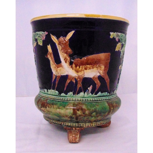 115 - Minton majolica circular plant stand decorated with deer by a tree all on three scroll legs, 39cm (h... 