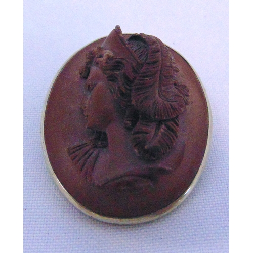 249 - An antique white metal and carved fruitwood brooch