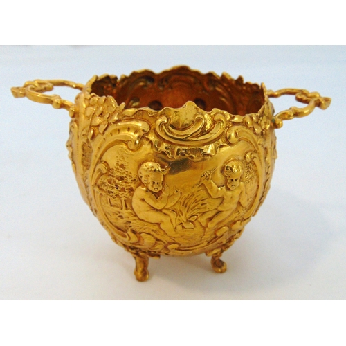 249 - A Dutch silver gilt bombe form sugar bowl chased with putti, flowers, leaves and scrolls with two si... 