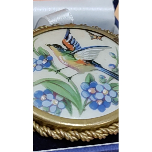 623 - LIMOGES France hand-painted enamel brooch features a colourful bird among blue floral motifs, encase... 