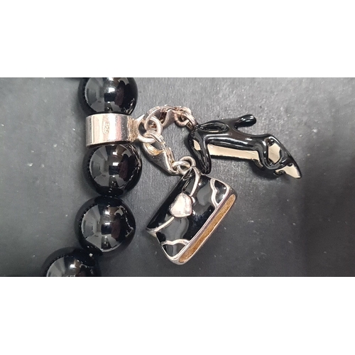 499 - Silver bracelet with black beads and a couple of charms 8cm across