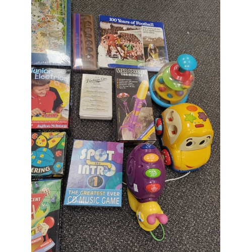 61 - Job lot of children's toys including puzzles, a rocket, model cars and a 100 years of football book