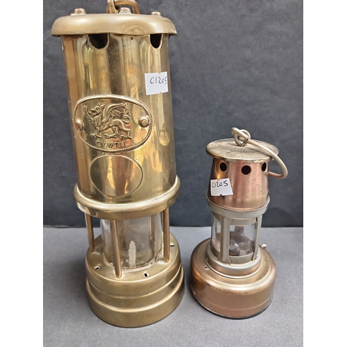 62 - A Cymru South Wales miners brass lamp H 21cm x W 8cm and a small copper and brass effect miners lamp... 