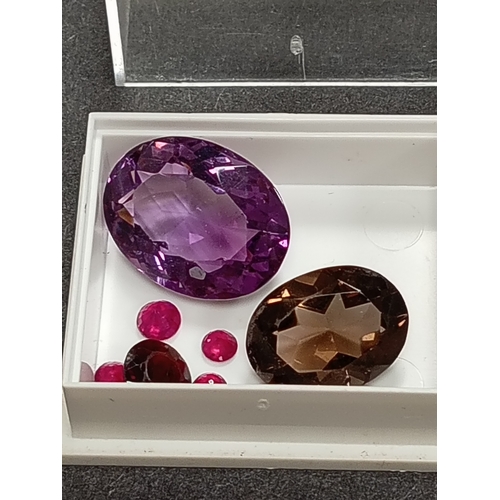 669 - Amethyst, smoky quartz, round cut rubies and a round garnet gem stones