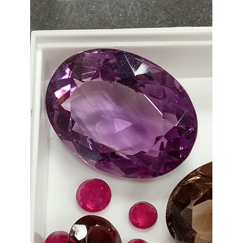 669 - Amethyst, smoky quartz, round cut rubies and a round garnet gem stones