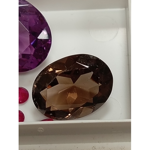 669 - Amethyst, smoky quartz, round cut rubies and a round garnet gem stones