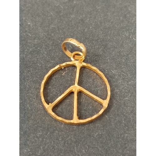 753 - 18ct peace sign pendant 1cm weight 0.67 grams