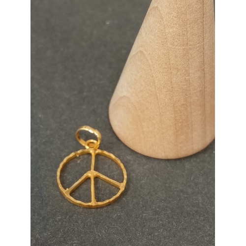 753 - 18ct peace sign pendant 1cm weight 0.67 grams