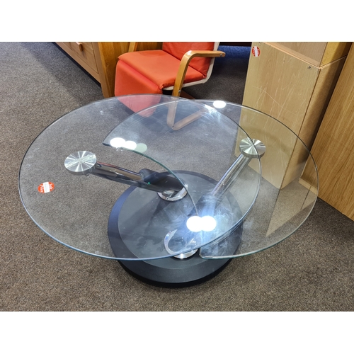 407 - Modern chromed round glass topped twist extendable coffee table which opens to the shape of an 8. H4... 