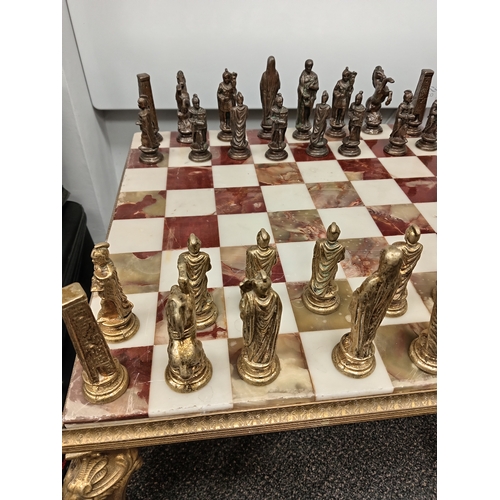 455 - Ornate brass and onyx chess table with full set of Roman brass chess pieces H 45cm x W 50cm