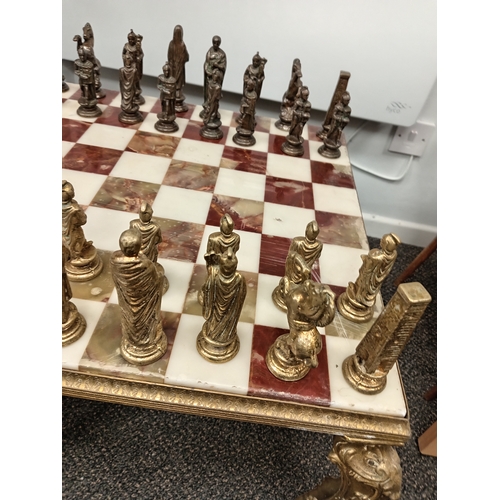 455 - Ornate brass and onyx chess table with full set of Roman brass chess pieces H 45cm x W 50cm