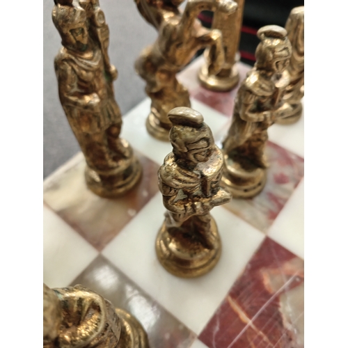 455 - Ornate brass and onyx chess table with full set of Roman brass chess pieces H 45cm x W 50cm