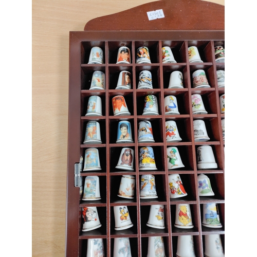 498 - Thimble wall display cabinet. Full of ceramic thimbles include. Elvis, Alice in Wonderland, Rupert t... 