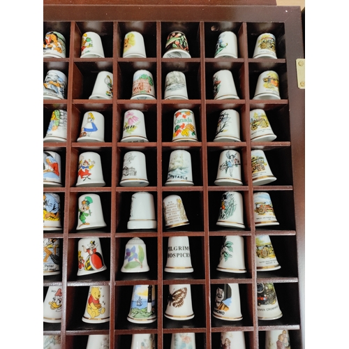 498 - Thimble wall display cabinet. Full of ceramic thimbles include. Elvis, Alice in Wonderland, Rupert t... 