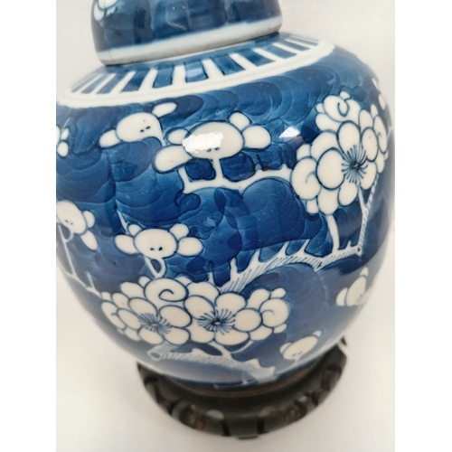 406 - Oriental Chinese blue and white prunus ginger jar on carved wooden stand H 19cm x W 13cm damage to l... 