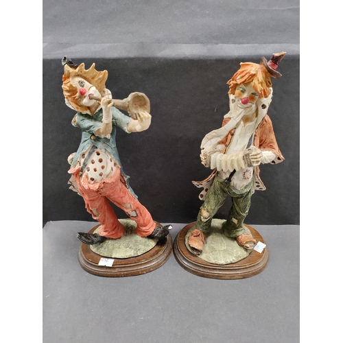 450 - A pair of resin clowns playing instruments. Clown with trumpet has small chip on foot.